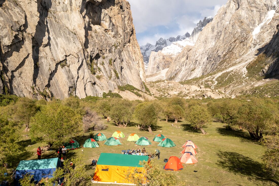 Aerial view of lunch at Mingulo Broq campsite with travellers seated outdoors in Nangma Valley Karakoram Mountains