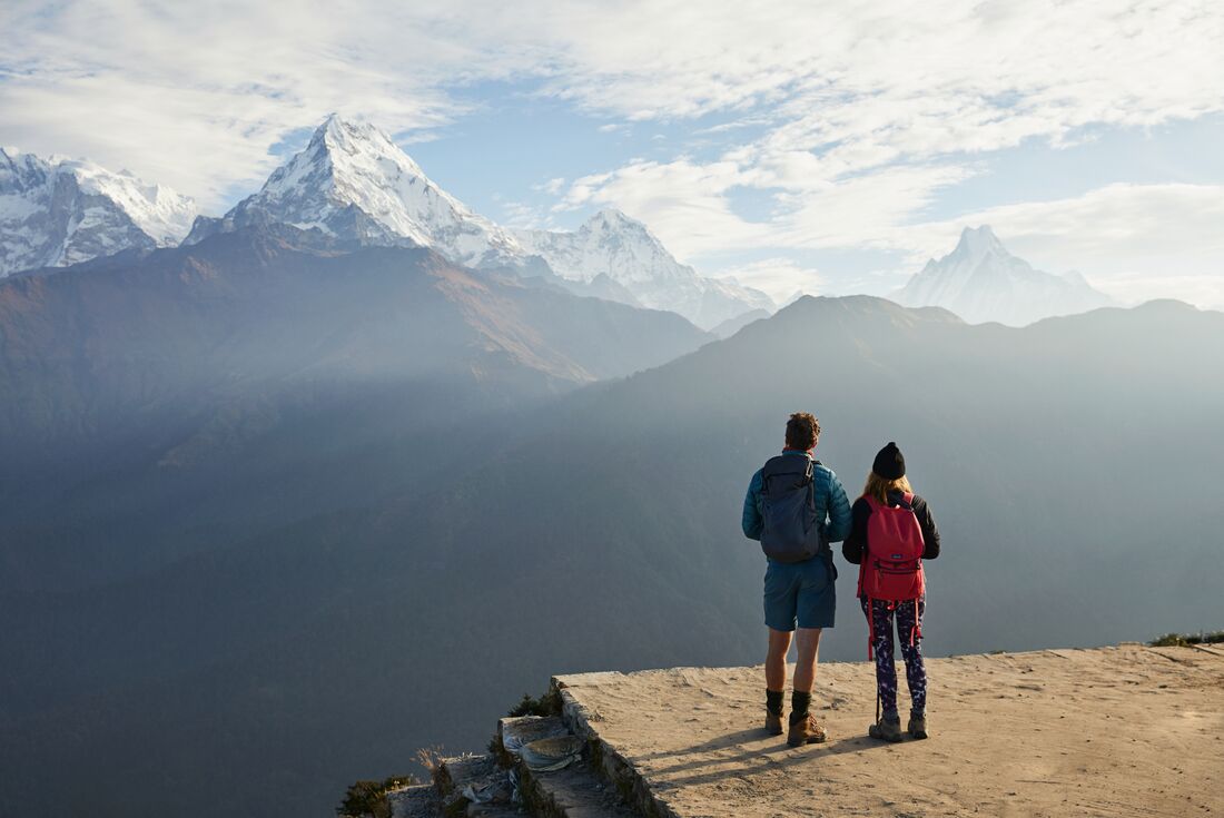 Intrepid travellers hiking in the Annapurna Foothills take in the view of the range from Poon Hill in Nepal