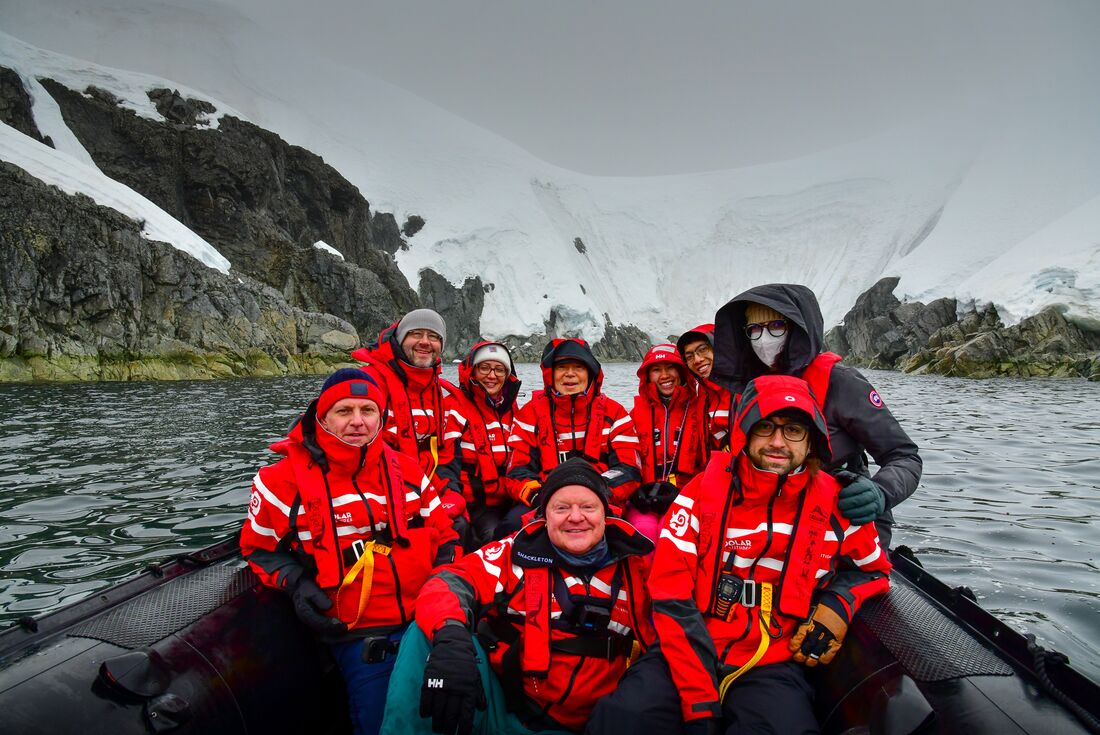 Travellers take a group shot on a zodiac ride off Melchior Islands in nothern Antarctica