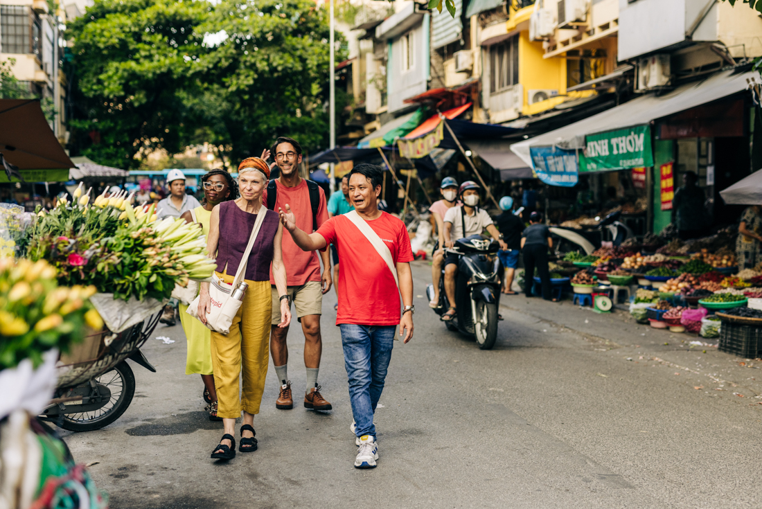 Intrepid leader and travellers walking through the streets of Hanoi