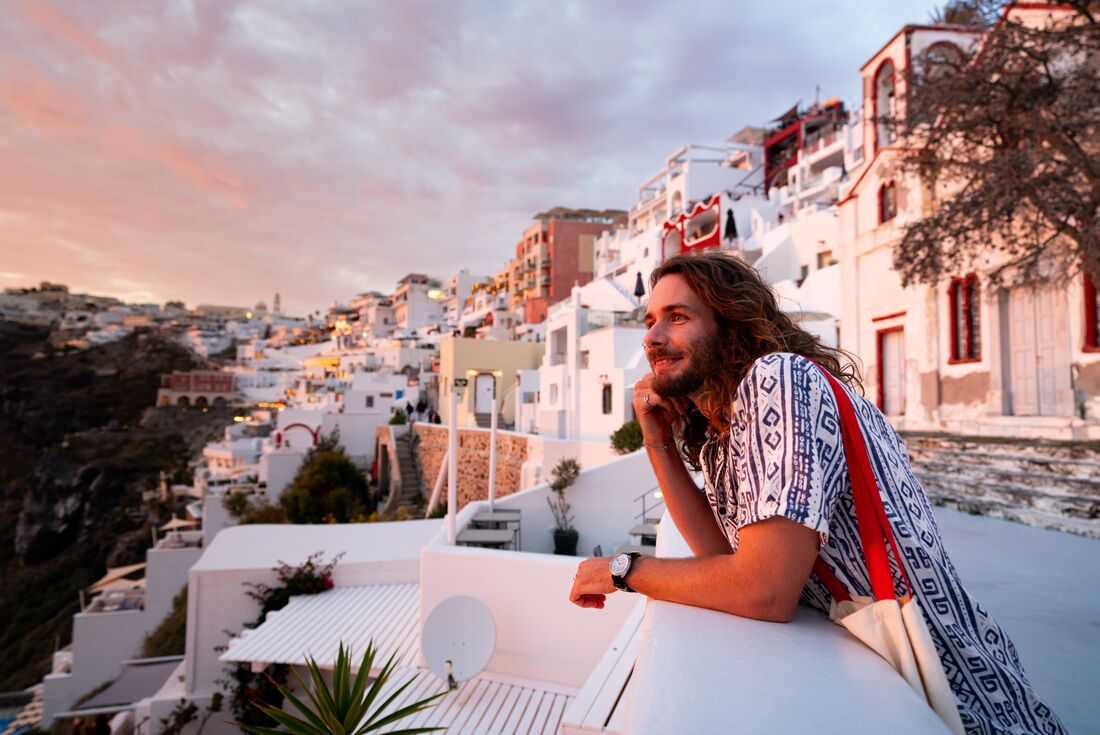 Traveller basks in the glow of the sunset in Santorini in the Cyclades of Greece