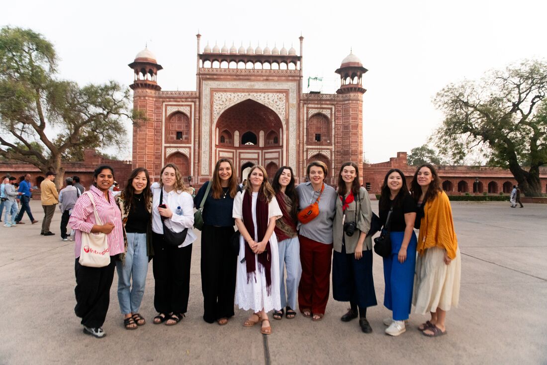 Travellers smiling as they take a photo in front of Jawab Masjid in Agra, India