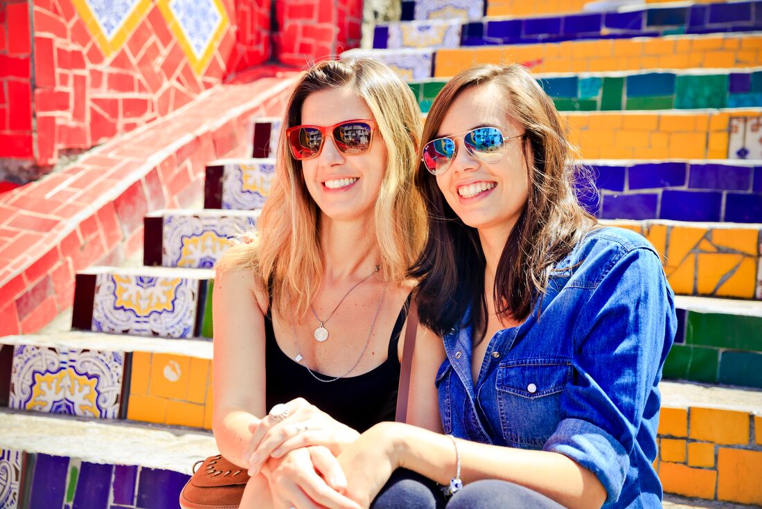 Travellers sit on the colourful steps of Escadaria Selaron, Rio de Janeiro, Brazil 