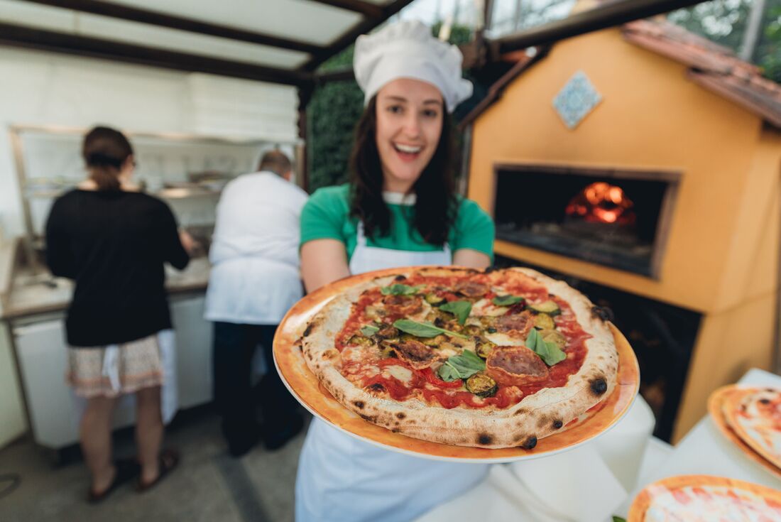 Traveller showing the pizza that she made to the camera 