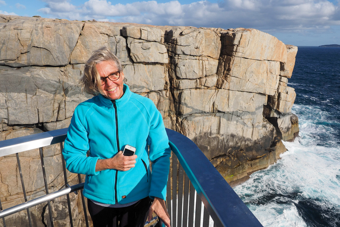 Intrepid traveller smiles against a railing on the Australian coast