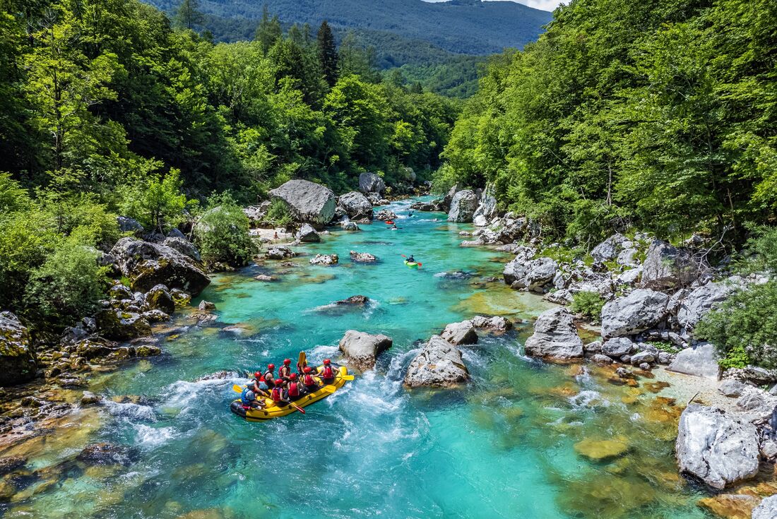 Intrepid travellers rafting down the Soca River with kayak guides in Slovenia