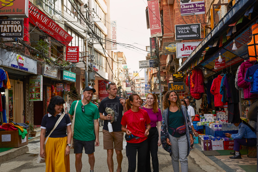 Group of Intrepid travellers with leader explore the streets of Kathmandu in Nepal