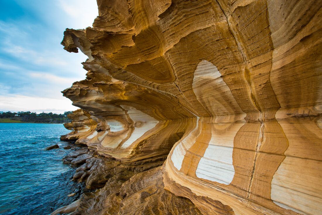 Painted cliffside on coast of Maria Island, Australia