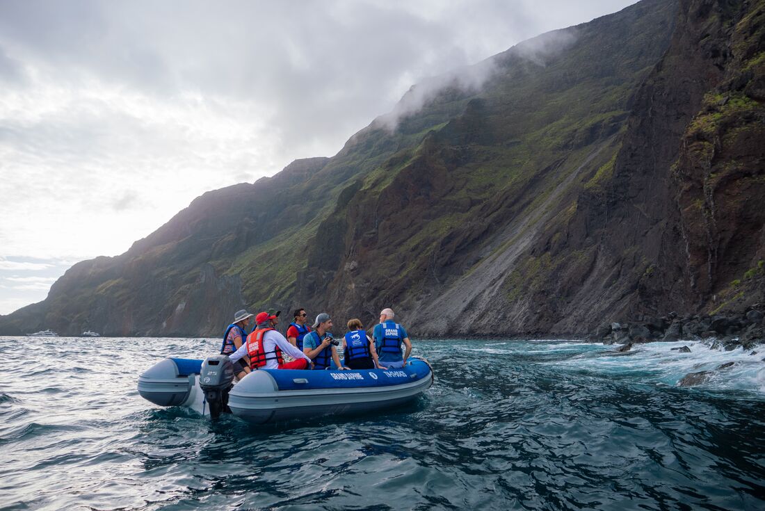 Intrepid group on a zodiac excursion around the mountainous coast of Isla Isabela in the Galapagos