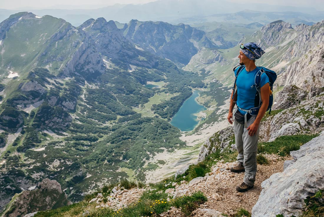 Man hiking in the mountains of Durmitor National Park overlooking Veliko Lake, Montenegro