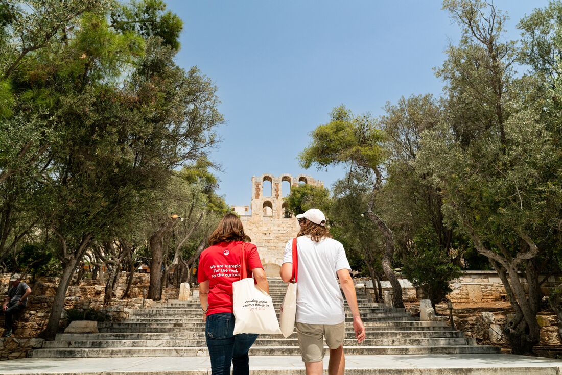 Intrepid leader and traveller walk toward a ruin monument in Athens Greece